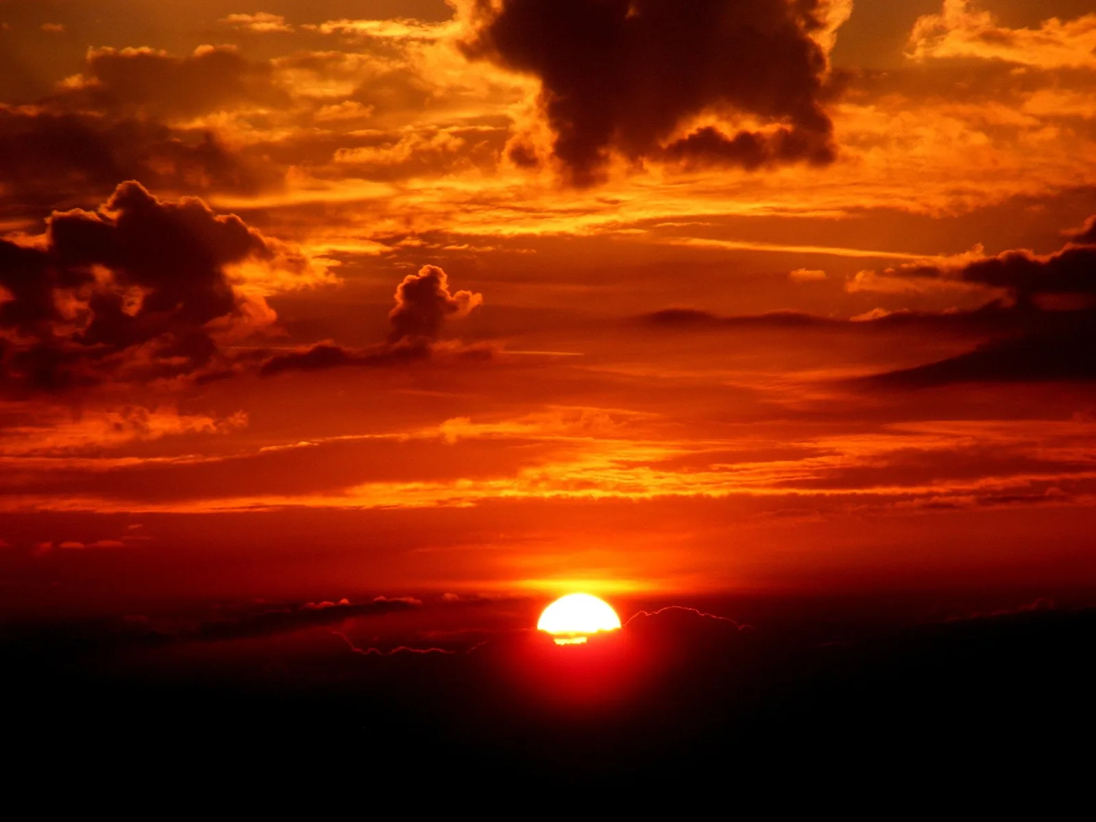 Tiefroter Sonnenuntergang mit Wolken, Symbolbild für die extreme Hitze in Kärnten und Osttirol