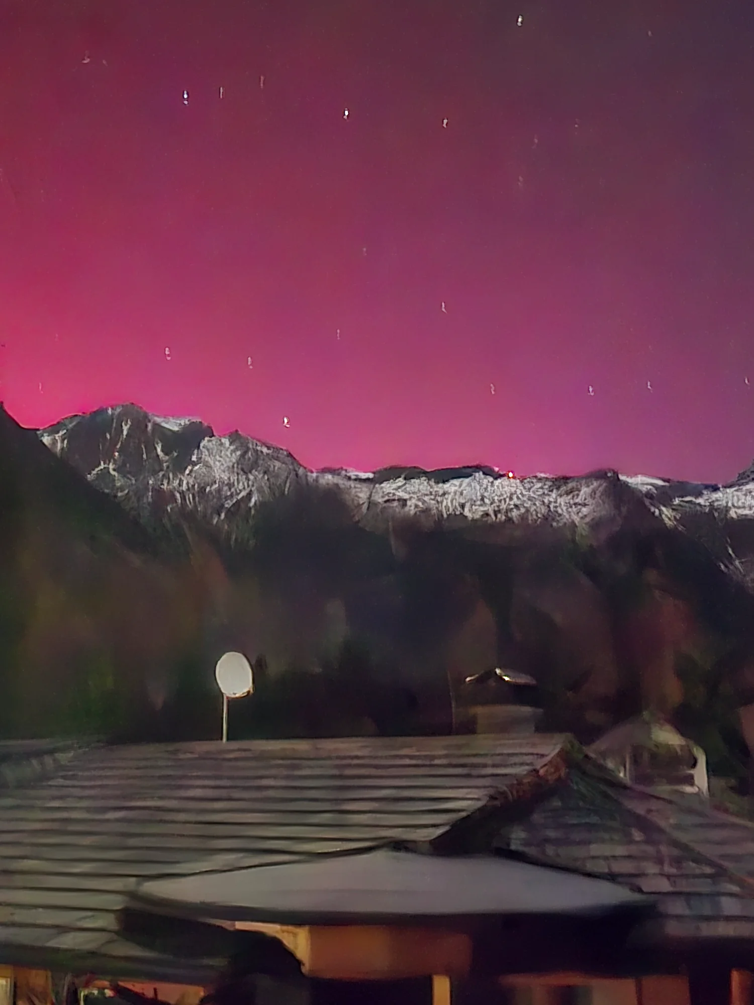 Polarlichter mit Sternenhimmel über verschneiten Bergen in Mallnitz